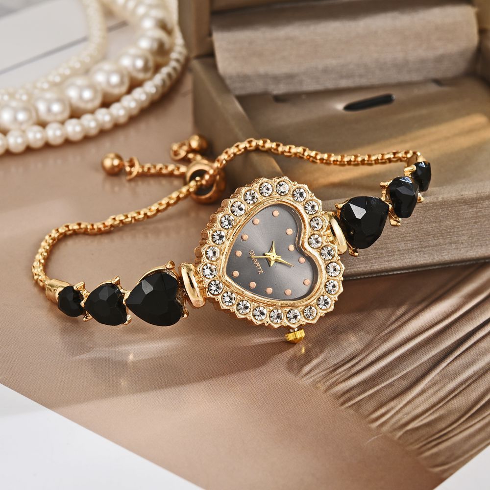 Exquisite heart-shaped quartz wrist watch with gold and black accents, featuring a stunning gem-studded design.